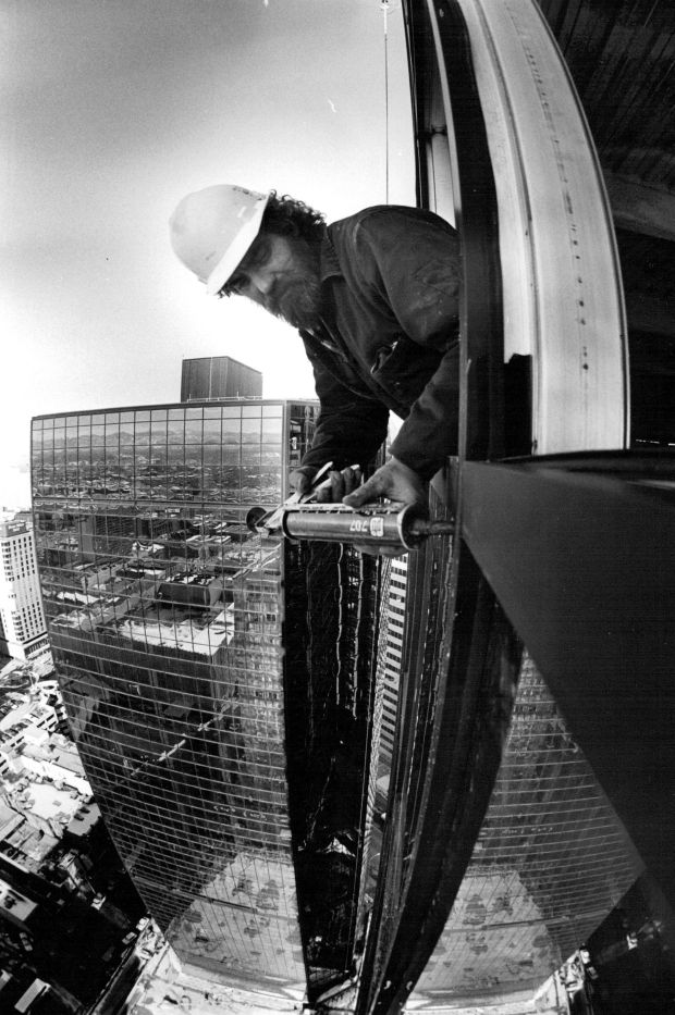 A worker hangs out of one of the twin 27- and 29-story towers of Great West Plaza, an office complex under construction at the triangular block where 16th Street meets Broadway in downtown Denver on Jan. 23, 1979. (Photo by Ernie Leyba/The Denver Post)