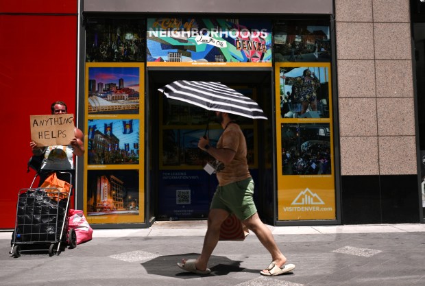 A man panhandles while pedestrians walk on 16th Street in Denver on May 13, 2025. (Photo by Helen H. Richardson/The Denver Post)